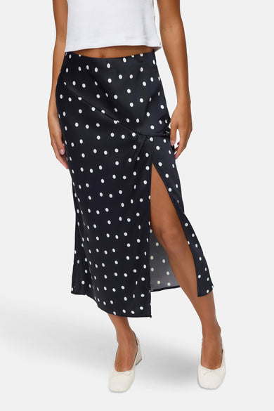 Longue jupe noire de VERO MODA®, avec des taches blanches et une haute fente.