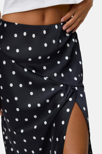 Robe longue noire de VERO MODA, avec des taches blanches et une fente sur le côté.