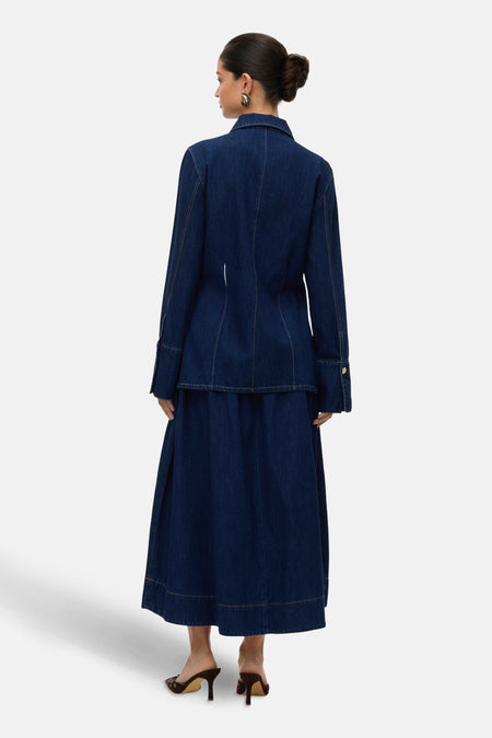 Jupe longue bleu marine en denim de VERO MODA, avec des coutures visibles et des talons hauts.