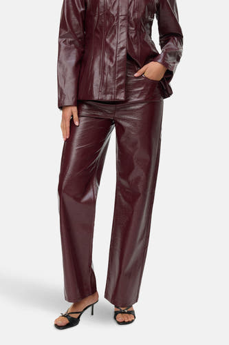 Pantalon Bordeaux de VERO MODA®, avec une texture brillante et associé à des bottes noires à lacets.