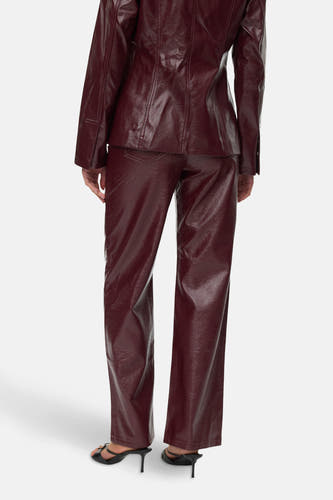Pantalon Bordeaux de VERO MODA, avec des jambes droites et porté avec des baskets noires.