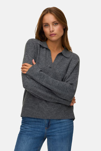 Sweat à capuche V de couleur grisère VERO MODA, porté avec un jean bleu et les bras croisés.