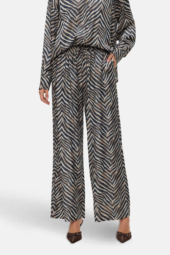 Pantalon multicolore de VERO MODA, avec imprimé zébré, larges pinces et associé à une blouse coordonnée.