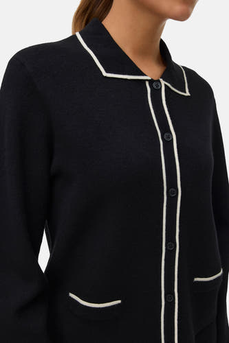 Gilet noir de Vero Moda, terminé avec un bord blanc le long des bords, fermeture à boutons et poches.