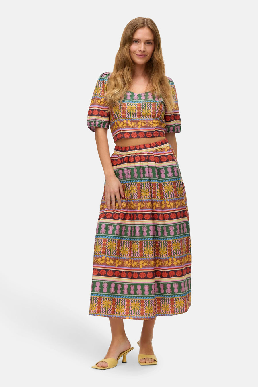 Robe longue multicolore de Vero Moda, avec une impression tropicale et associée à un haut coordonné et des chaussures jaunes.