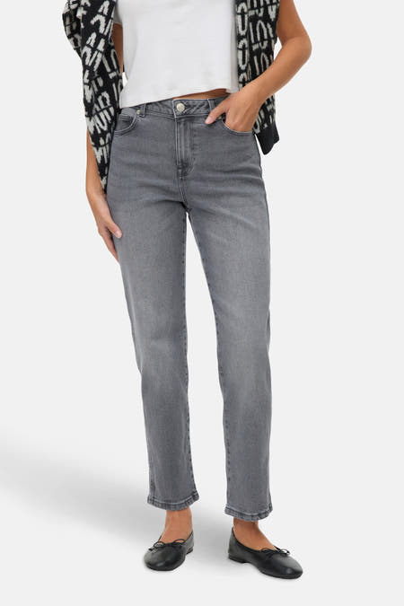 Jean droit gris de VERO MODA, avec des poches et porté avec un t-shirt blanc et une veste noir et blanc.