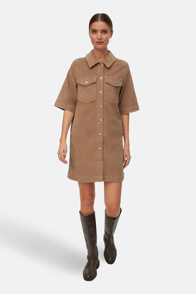 Manteau beige à manches courtes de VERO MODA, avec fermeture à boutons et poches, porté avec des bottes.