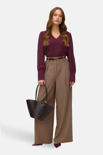 Blouse Bordeaux à longues manches de VERO MODA, avec des manches pliées, associée à un pantalon marron, une ceinture et un sac.