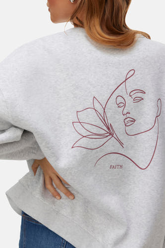 Gilet gris de VERO MODA avec une femme abstraite et des fleurs sur le dos.