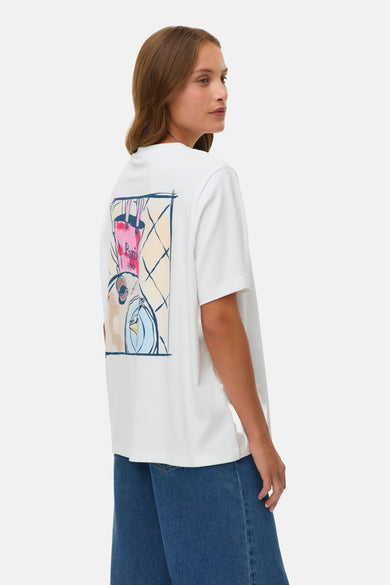 T-shirt blanc à manches courtes VERO MODA®, avec 'Paris 1970' en bleu sur la poitrine, porté avec un jean ample.