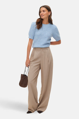 Beige broek van VERO MODA, met wijde pijpen en een hoge taille, gecombineerd met een bruine handtas.
