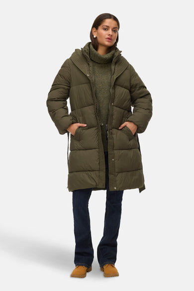 Manteau long vert de VERO MODA, avec un capuchon et une ceinture, porté avec des jeans foncés et des chaussures marrons.