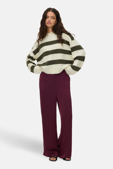 Sweat-shirt multicolore à col rond de VERO MODA, avec des rayures horizontales et porté avec un pantalon bordeaux.