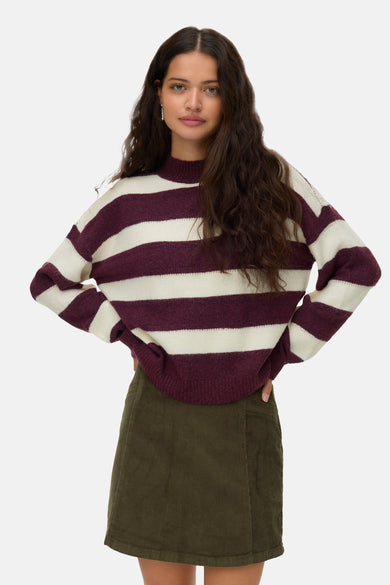 T-shirt rouge avec col rond de VERO MODA, avec des larges rayures blanches et une jupe en corduroy verte.