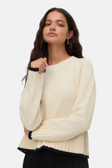T-shirt écru avec col rond de VERO MODA, terminé avec des accents bleus foncés, porté avec des boucles d'oreilles d'.