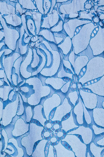 Détail d'un short bleu clair de VERO MODA avec un motif floral en dentelle.