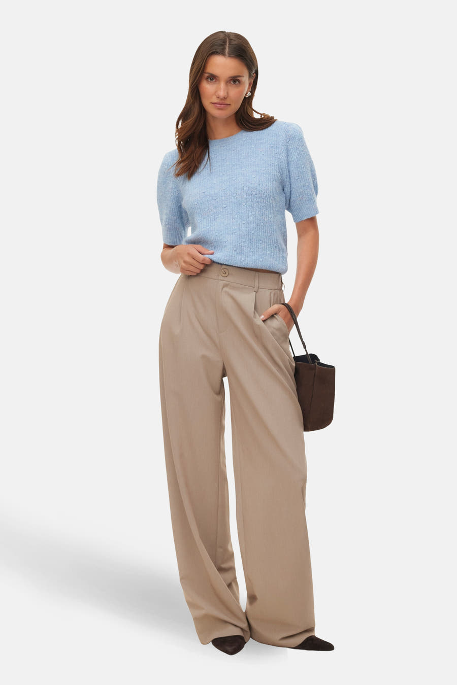 Blauwe trui met ronde hals van VERO MODA, met korte mouwen en een subtiele textuur, gecombineerd met een bruine tas en wijde, beige pantalon.