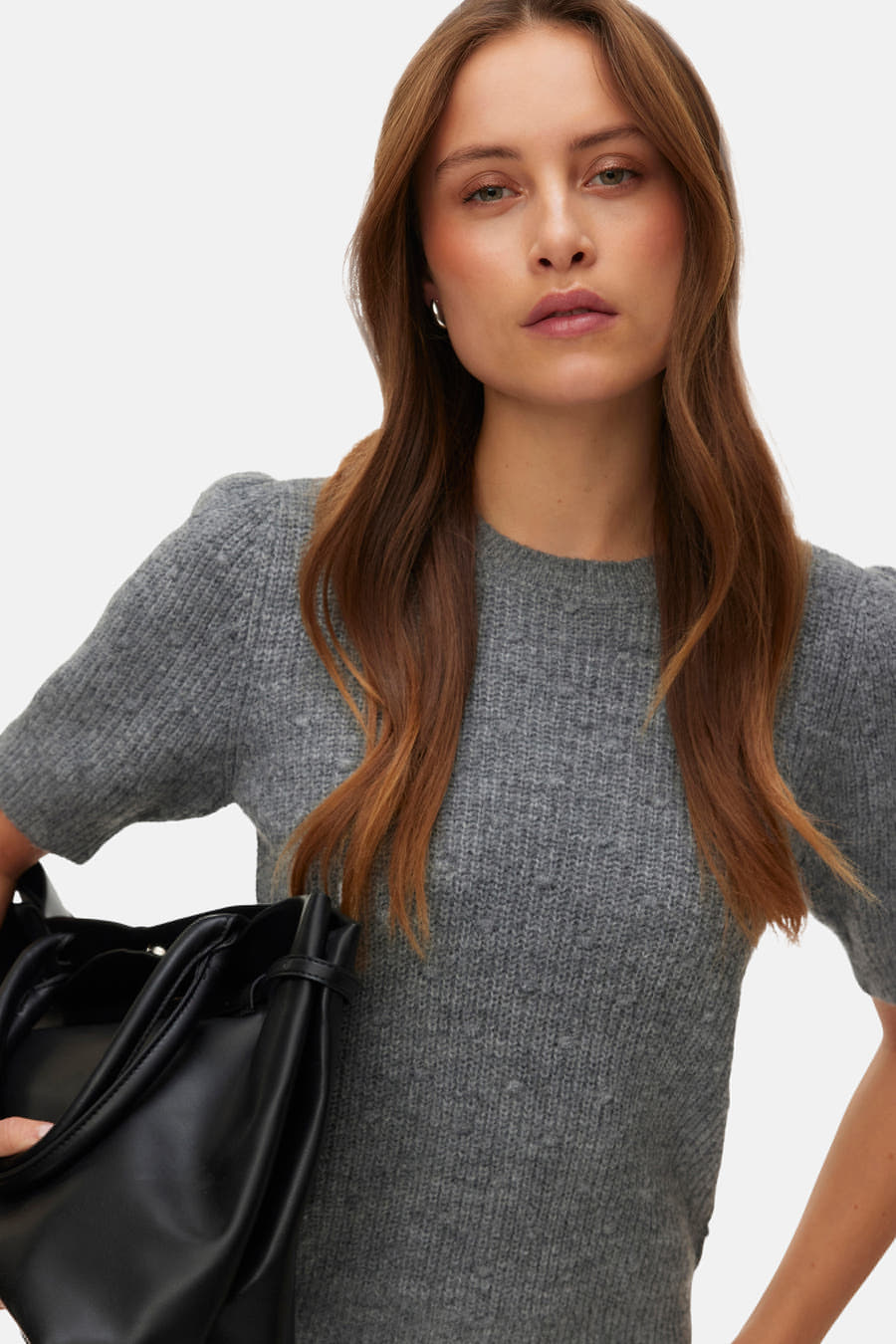 Sweat-shirt gris à col rond de VERO MODA®, tailleur, avec des manches courtes et porté avec un pantalon noir.