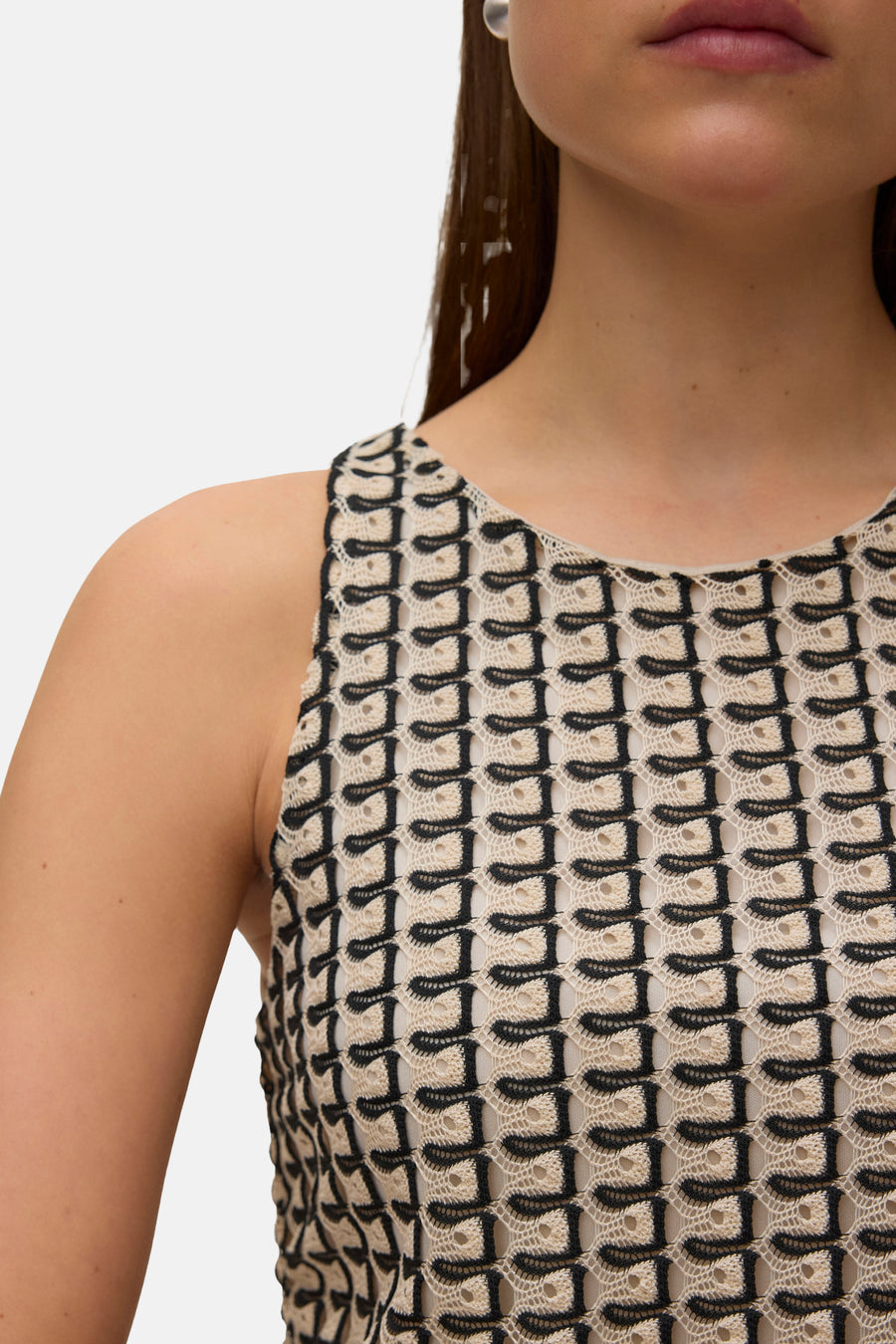 Multicolor mouwloze top van VERO MODA® met zwart-wit geometrisch kantpatroon, close-up voorzijde