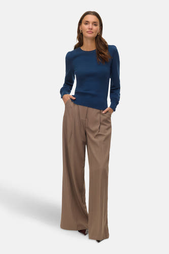 Blauwe trui met ronde hals van Vero Moda, met lange mouwen en een fijne ribgebreide textuur, gedragen met een bruine pantalon.
