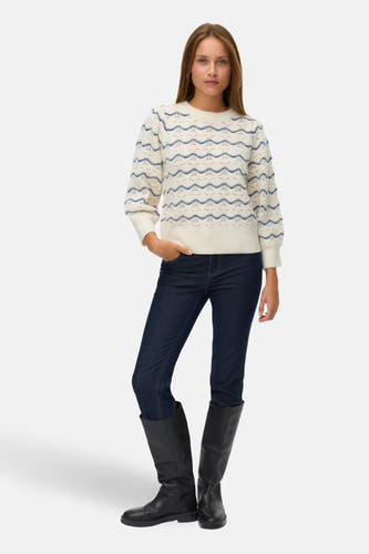 Blauwe trui met ronde hals van VERO MODA, met decoratief patroon, gecombineerd met donkerblauwe jeans en zwarte laarzen.

