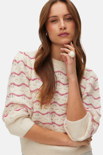 Sweat-shirt à col rond de VERO MODA avec un motif zigzag rouge et des manches trois-quarts, porté avec un short blanc.