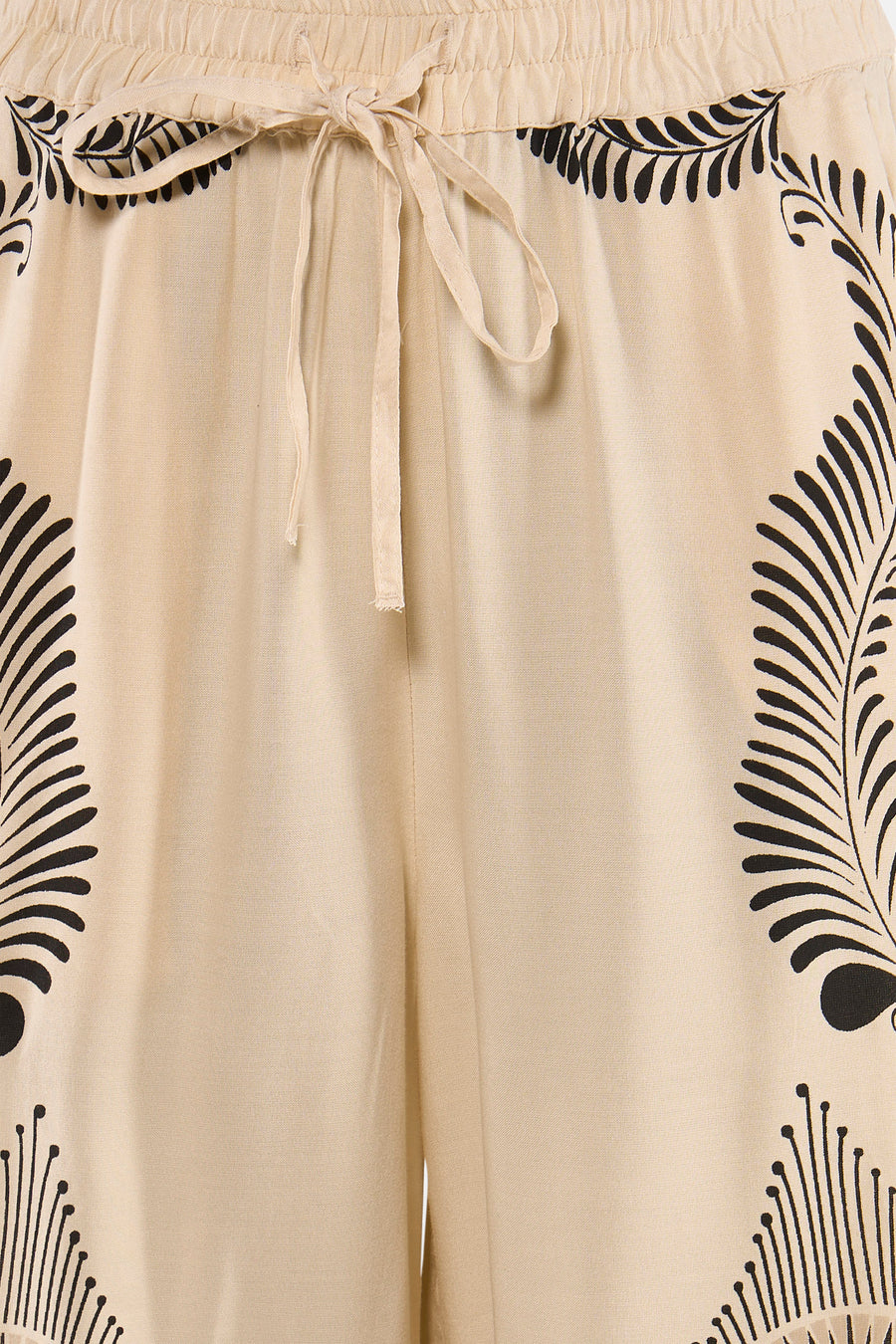 Crèmekleurige broek met zwart bladpatroon van VERO MODA®, elastische taille met strik, lichte stof, close-up vooraanzicht
