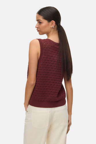 Débardeur de couleur brique de VERO MODA, avec un motif ajouré et associé à un pantalon blanc.