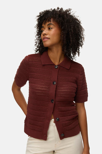Gilet marron de VERO MODA, à manches courtes, porté avec un pantalon beige et des chaussures noires.