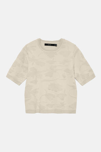 Pull écru à col rond de VERO MODA, avec un motif floral subtil et des manches courtes.