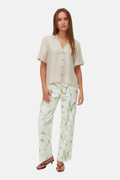Ecru hemd met korte mouwen van Vero Moda, met knoopsluiting en gedragen met een witte broek met bloemenprint.