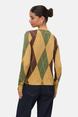 Sweat-shirt bleu avec col rond de VERO MODA, motif à carreaux d'argyle en vert et marron, associé à des jeans foncés.
