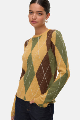 Sweat-shirt à col rond de VERO MODA, avec un motif argyle marron et vert, porté avec des jeans foncés et des boucles d'oreilles argentées.