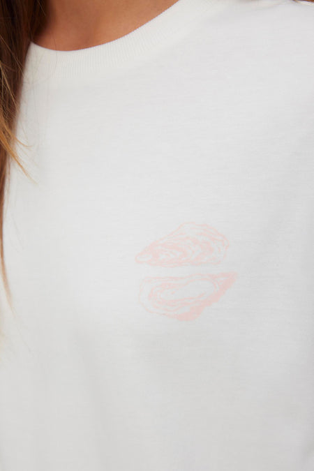 T-shirt blanc VERO MODA® avec un imprimé d'huître stylisée rose clair sur la poitrine.