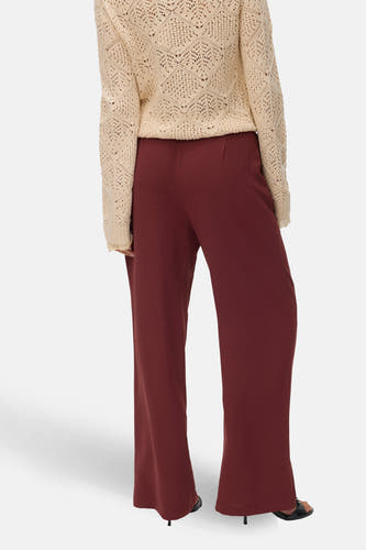 Pantalon brun de VERO MODA, avec des jambes larges et une texture lisse, associé à un pull tricoté.