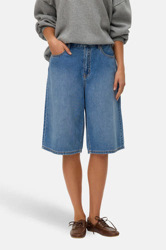 Short en jean bleu moyen de VERO MODA, avec poches arrière, combiné avec un pull gris à imprimé café.