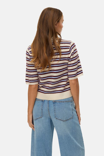 Ecru trui met V-hals van Vero Moda, met blauwe en bordeaux gestreepte patroon, gecombineerd met lichtblauwe jeans.
