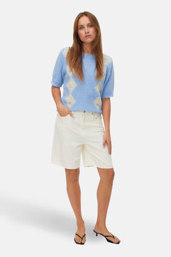 Blauwe trui met ronde hals van VERO MODA, met geborduurde ruiten en korte mouwen, gecombineerd met een witte short en zwarte slippers.
