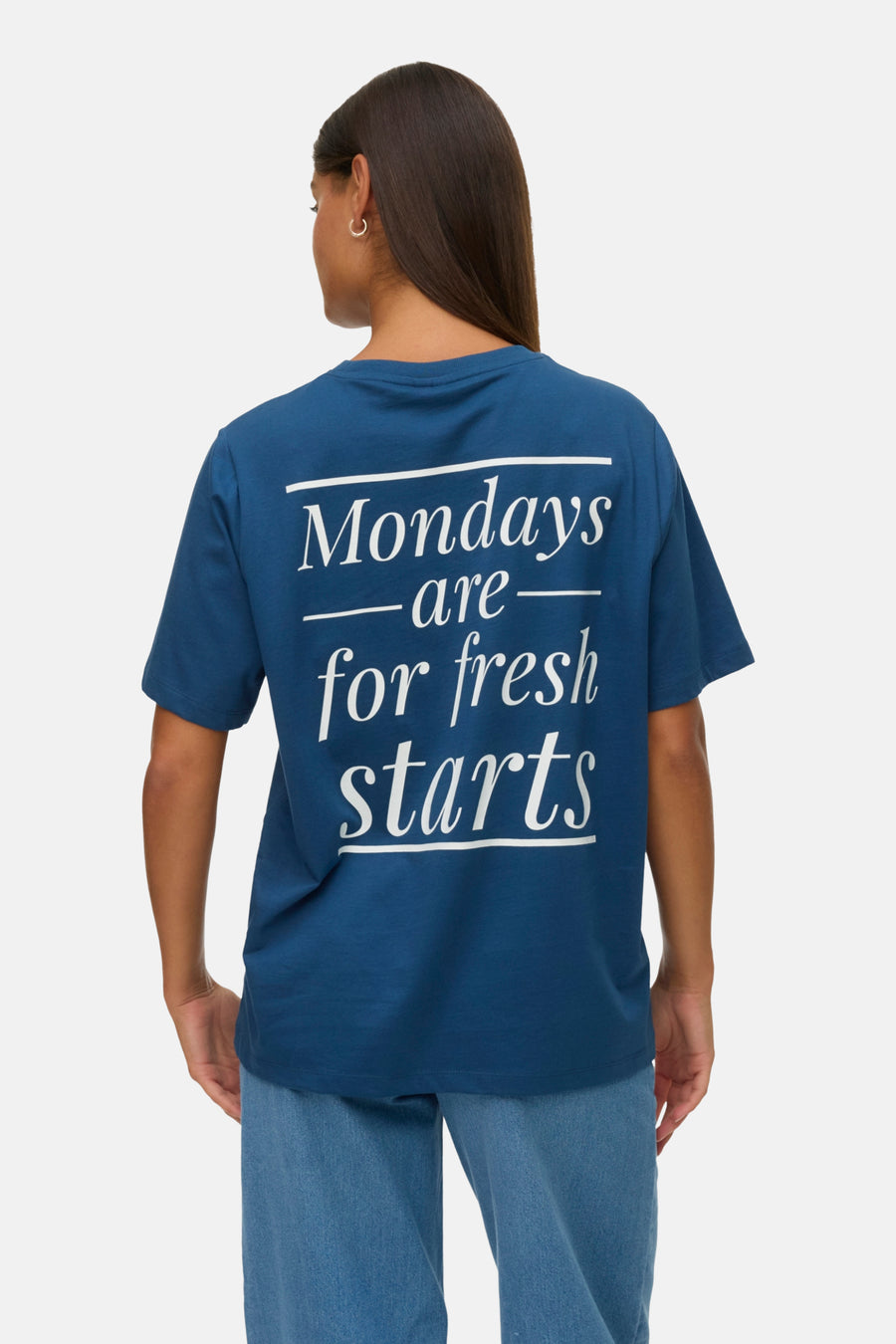 Blauw T-shirt met witte tekst "Mondays are for fresh starts", achterkant, vrouw met spijkerbroek.