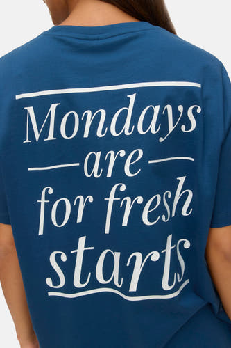 T-shirt bleu à manches courtes de VERO MODA® avec imprimé texte blanc sur le dos.