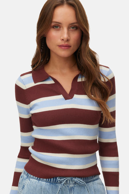 Pull multicolore à col en V de VERO MODA®, avec rayures horizontales et manches longues, associé à un pantalon en jean.