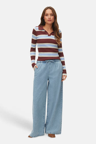 Multikleurige trui met V-hals van VERO MODA® met horizontale strepen en lange mouwen, gecombineerd met wijde jeans en bruine schoenen.
