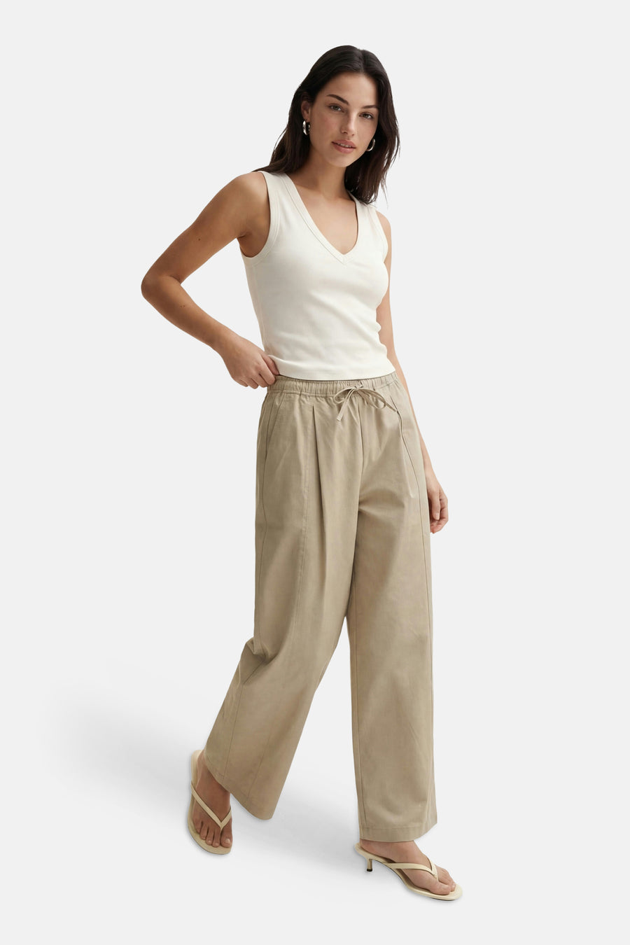 Witte mouwloze top met V-hals van VERO MODA®, gedragen met beige wijde broek en sandalen, front view