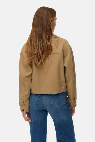 Bruine korte jas van Vero Moda, met lange mouwen en een klassieke kraag, gedragen met jeans.