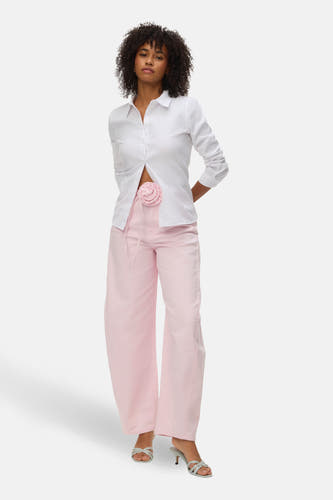 Roze gekleurde jeans van VERO MODA, met wijde pijpen en een decoratieve bloem op de tailleband.
