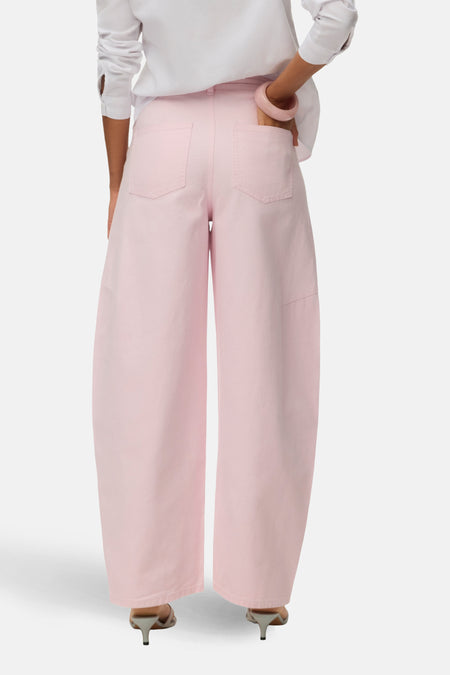 Roze gekleurde jeans van VERO MODA, met wijde pijpen en achterzakken, gecombineerd met een witte blouse en hakken.