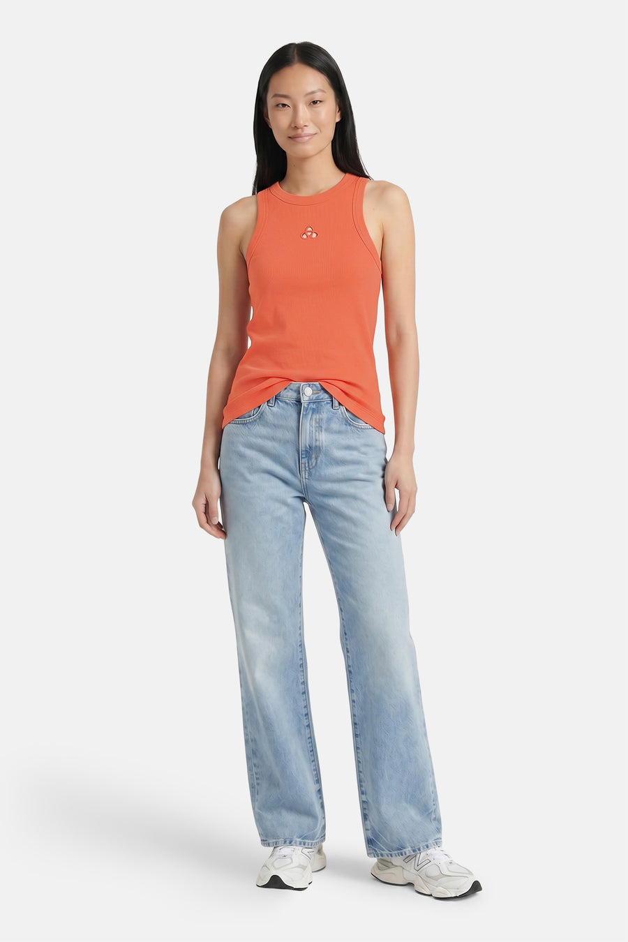 Oranje ribbel tanktop van VERO MODA® met klein logo, gedragen met lichtblauwe jeans en witte sneakers, front view