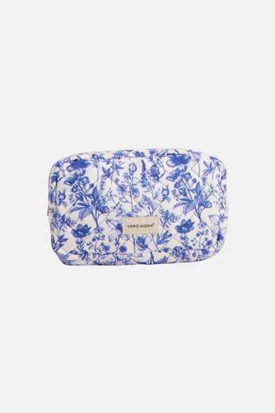 Trousse de toilette bleue de VERO MODA avec un imprimé floral blanc et une fermeture éclair dorée.
