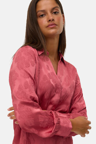 Chemise rose à longues manches de VERO MODA, avec un motif de feuille subtil et des bras croisés.