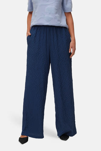 Pantalon bleu VERO MODA® avec un tissu texturé et des jambes larges, vu de dos.
